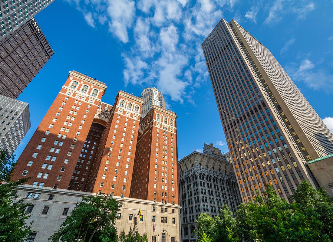 Blog - View of Skyscrapers Surrounded by Green Foliage in Downtown Pittsburgh Pennsylvania Against a Bright Blue Sky